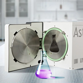 A conical flask of liquid in front of an autoclave with a conical-flask-shaped hole in the chamber