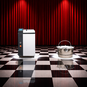 A laboratory autoclave next to a clinical discard container displayed on a stage, with a glowing neon sign in the background asking ‘Calibration or Validation?’