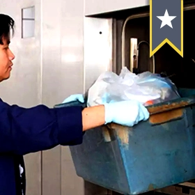 A man loading a container into an autoclave
