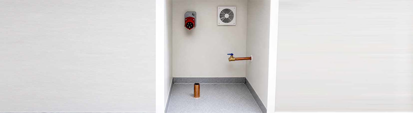 An electrical socket, drain pipe, water connection, and air vent at an autoclave installation site.