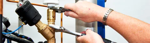 Astell service engineer using spanners to adjust autoclave pipework